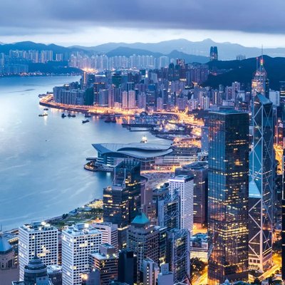 Hong Kong skyline at dusk, lights reflecting over Victoria Harbour