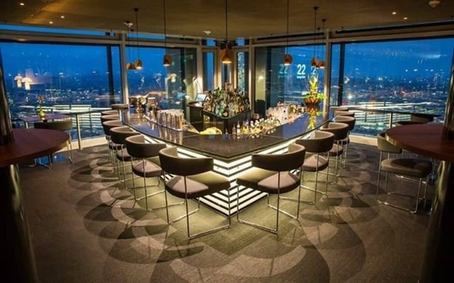 Elegant rooftop bar in Frankfurt with panoramic night views of the city skyline
