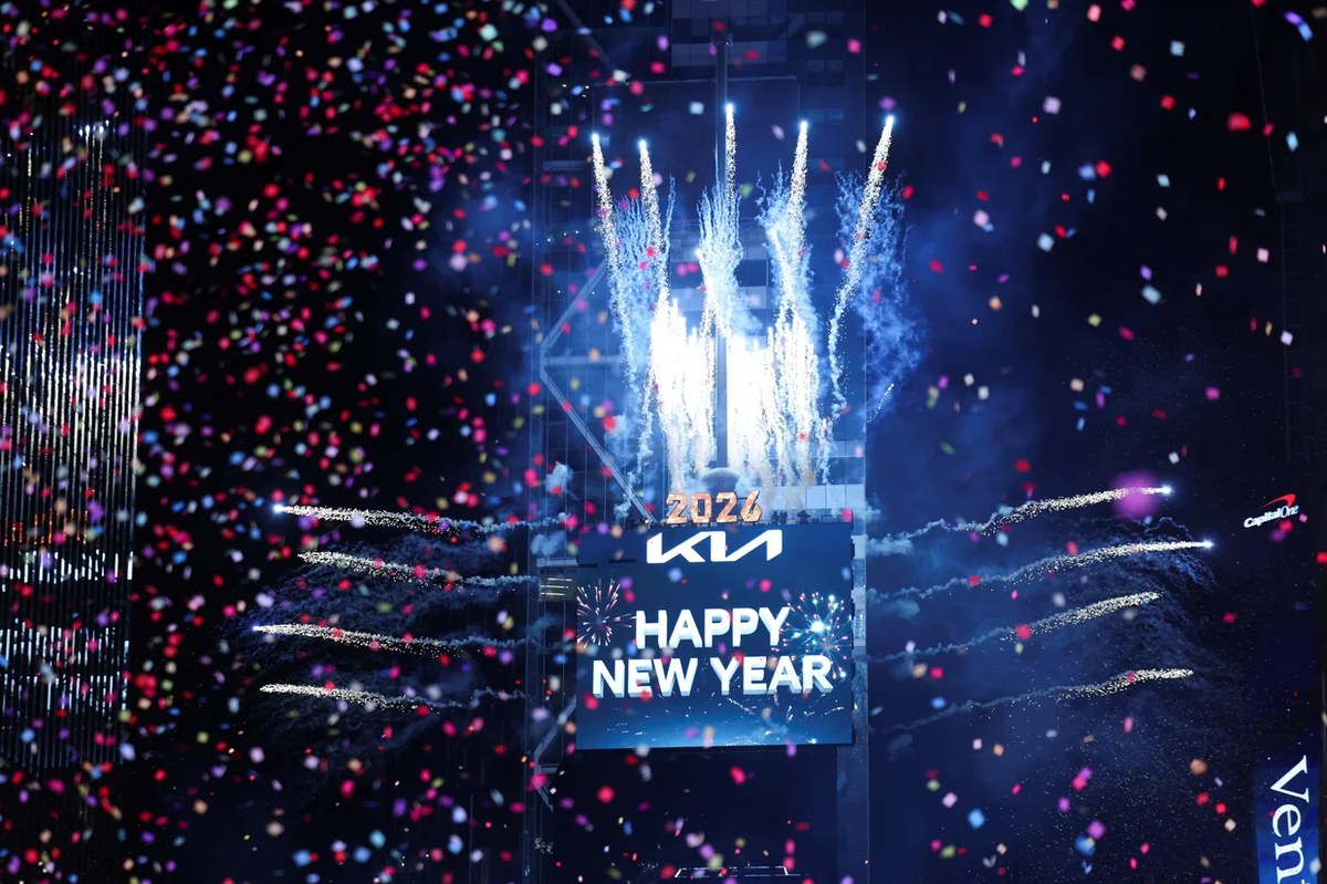 NYE 2026 in New York: confetti and fireworks burst over Times Square as the Happy New Year sign lights up.